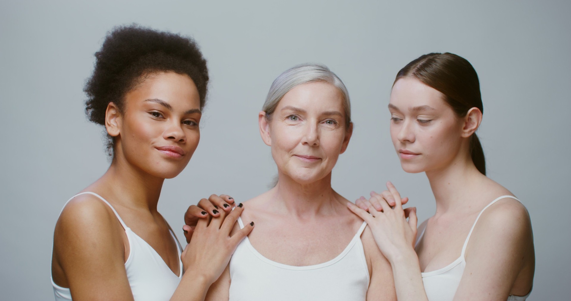 Caucasian models with large age differences stand beside African-American woman